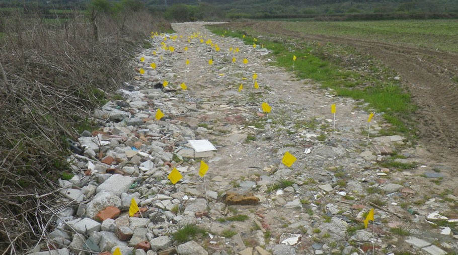 Yellow flags mark the spots where asbestos was found on farmland