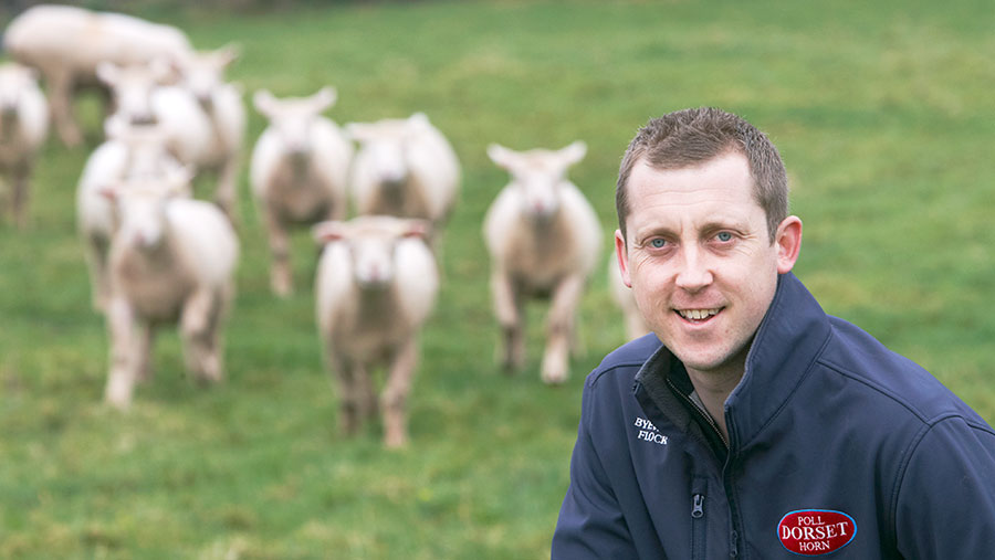 Joe Larder in a field with sheep