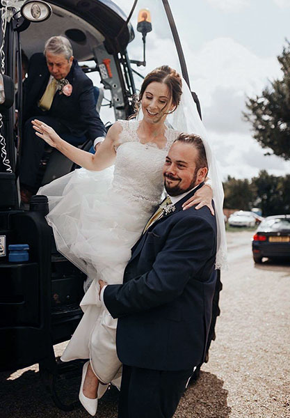 Harriet Hayward climbing out of a tractor in her wedding dress