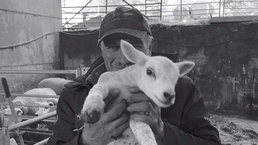 Arthur Threlkeld holds a lamb up