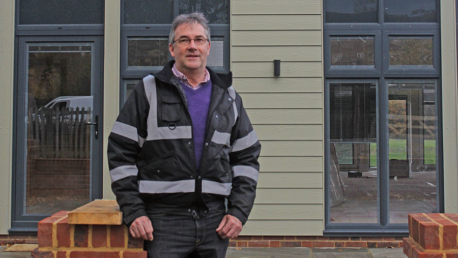 William Ashley stands outside a barn