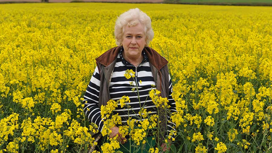 Arable farmer Sally Thomas stands in a field of oilseed rape
