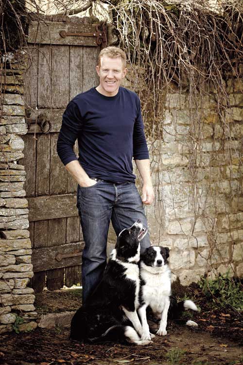 Adam Henson stands with two dogs