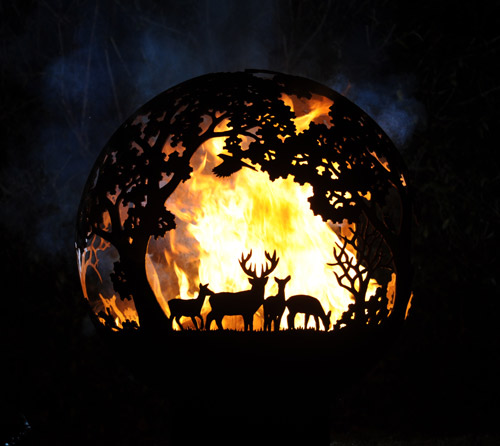 One of Andy Gage's fireballs - a steel fire pit with a deer and trees motif