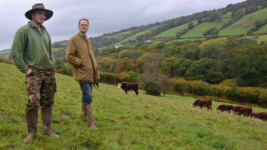 Alex Fraser and Ben Williams stand in an upland pasture