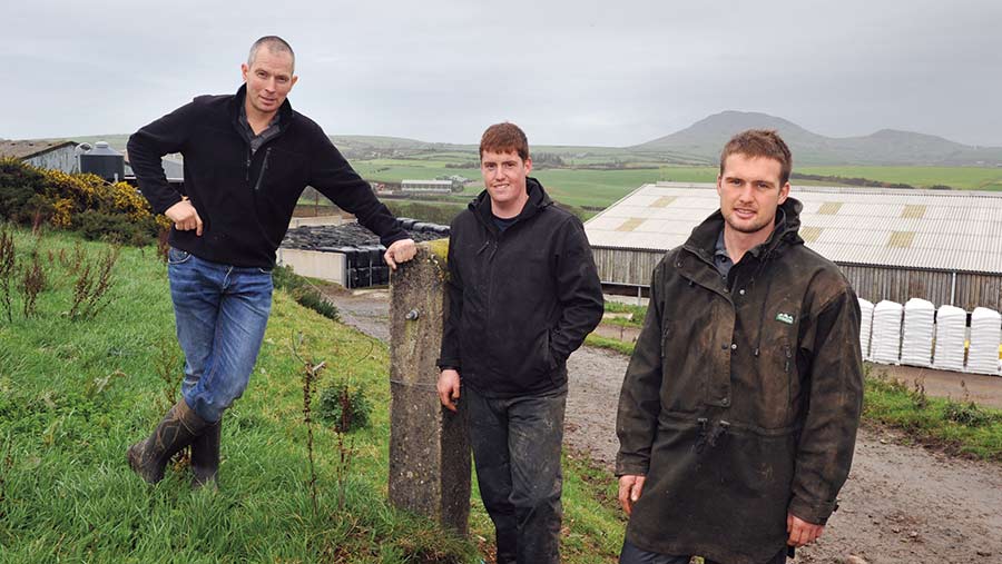 Rhys Williams leans on a post. Next to him are Tomos Huws and Llyr Roberts