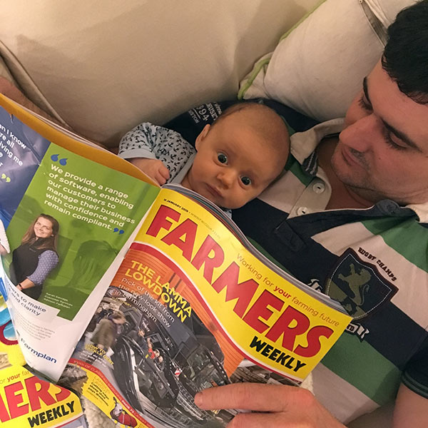 Baby George with Dad Matt reading Farmers Weekly