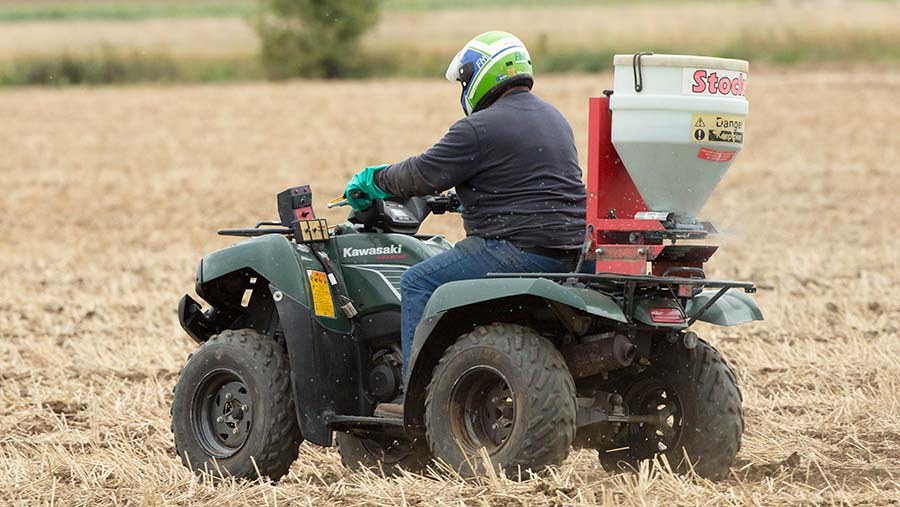 An ATV being operated safely by a driver wearing a helmet