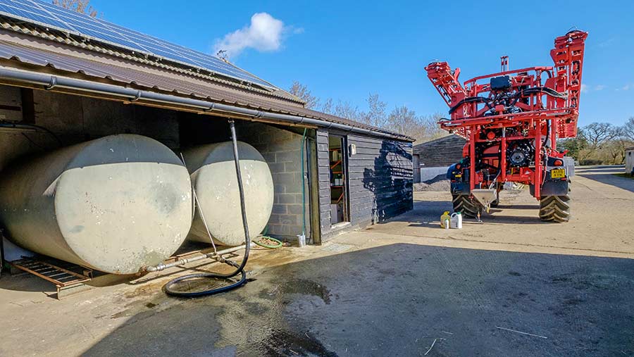 Crop sprayer next to water tanks in yard