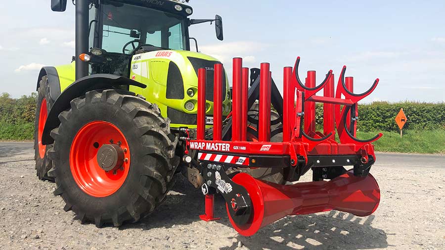 A bale-wrapper on the front of a tractor