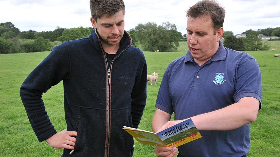 Rob Mitchell and Mark pass reading a booklet in a field