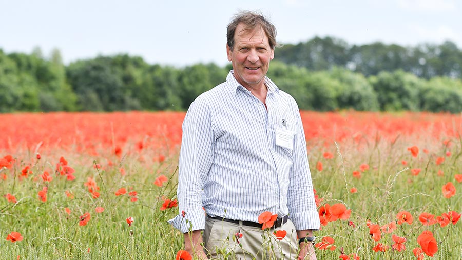 Richard Thompson in a field of barley with poppies