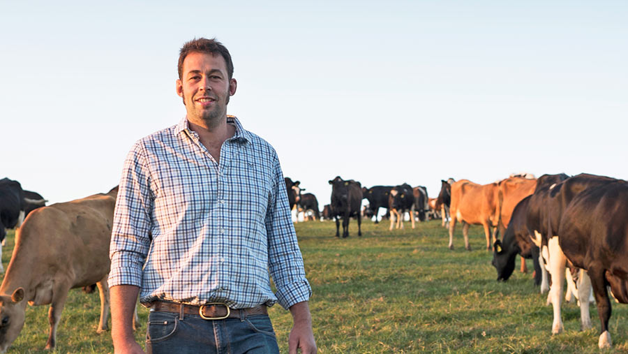 Sam Parker in a field with cows in the background