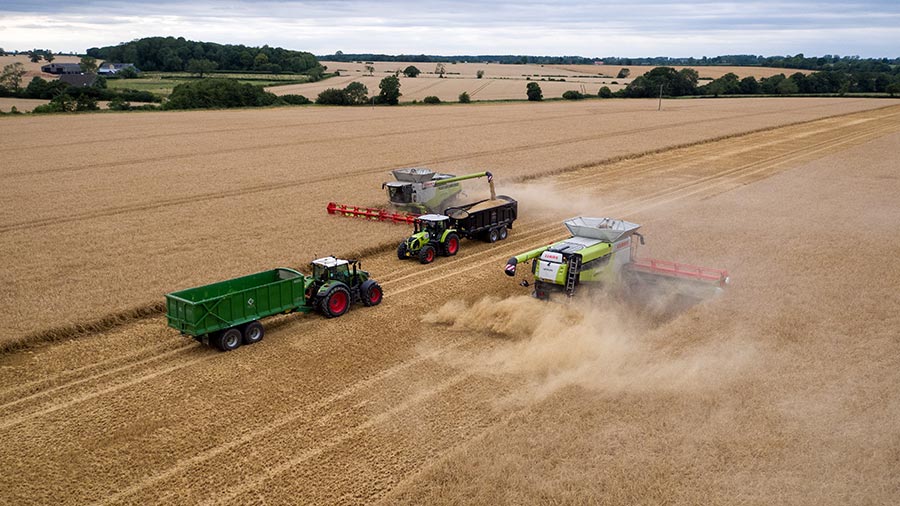 Two combines and two tractors harvesting by Freddie Gittus