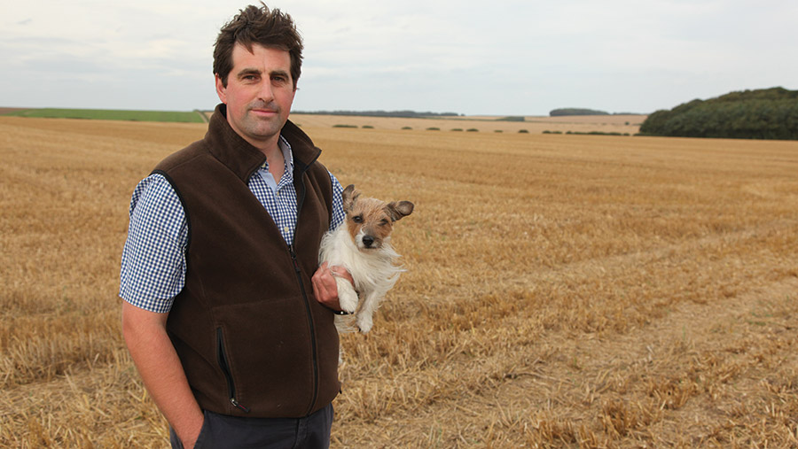 James Grandy holding dog in field