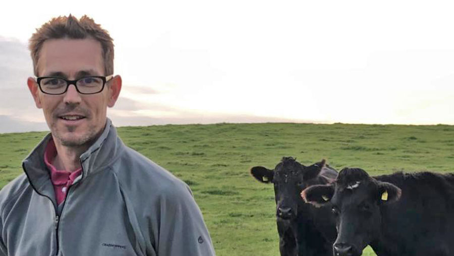 Oliver Surman in a field with cows