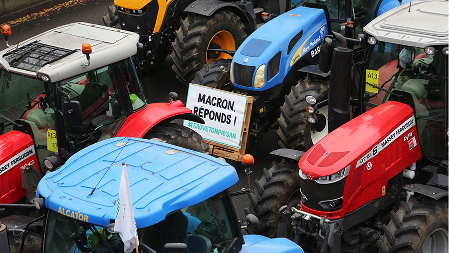 French farmers block the Parisian ring road with their tractors displaying placards reading 'Macron, answer!'