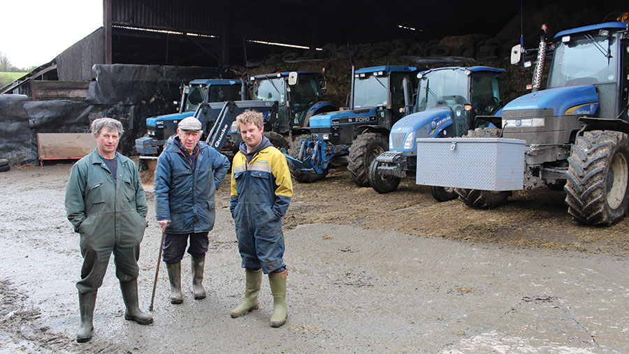 Paul, John and Andrew  Gould  standing in front of machinery shed