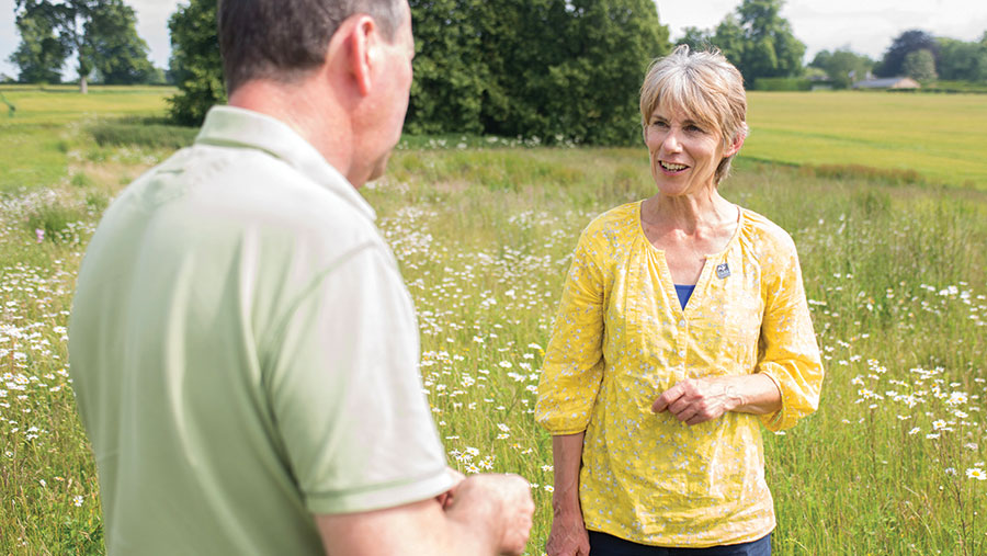 Alison Cross in a field with farmer