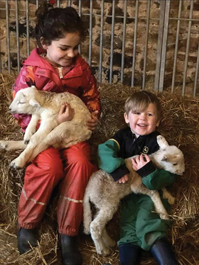 Daisy and Hamish holding lambs