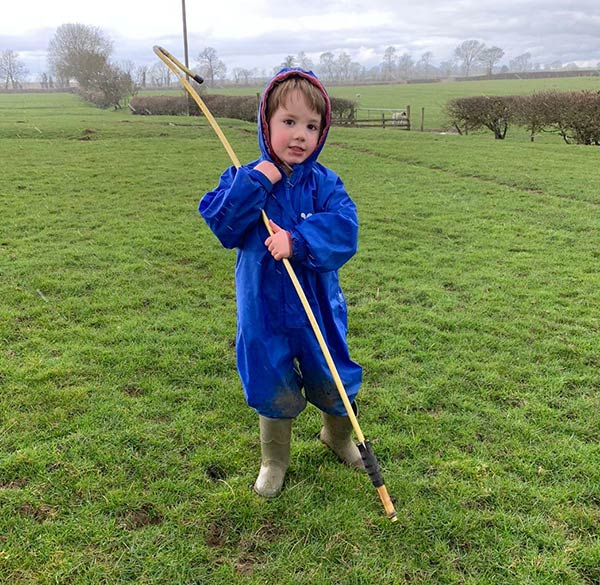 Four-year-old Jack helping his grandad move sheep and lambs.