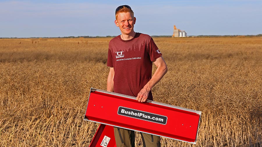 Marcel Kringe holding Bushel Plus system in field