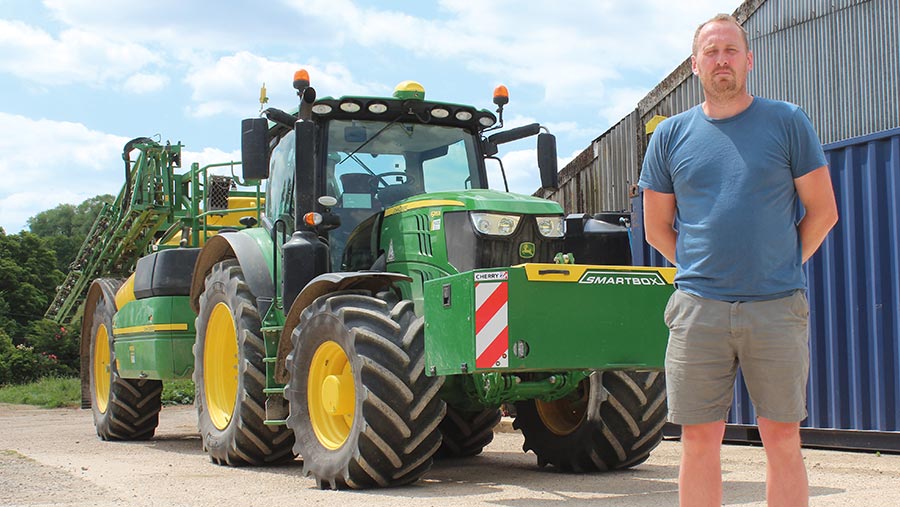 Tristan Newens standing next to tractor