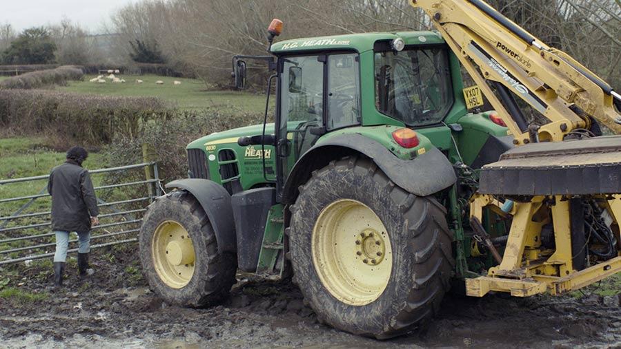 Tractor with a hedgetrimmer attached