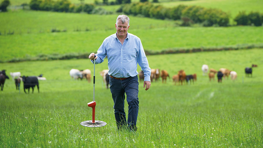 Sam Chesney in field with grass meter