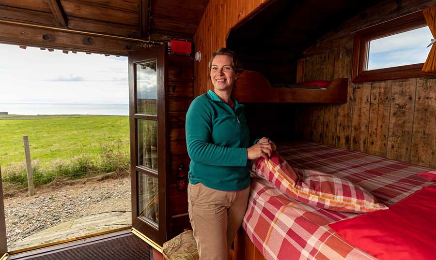 Carole Short making the bed in a cabin