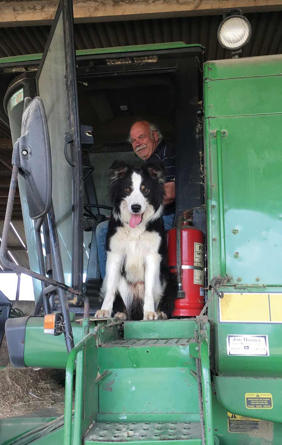 man and dog in combine