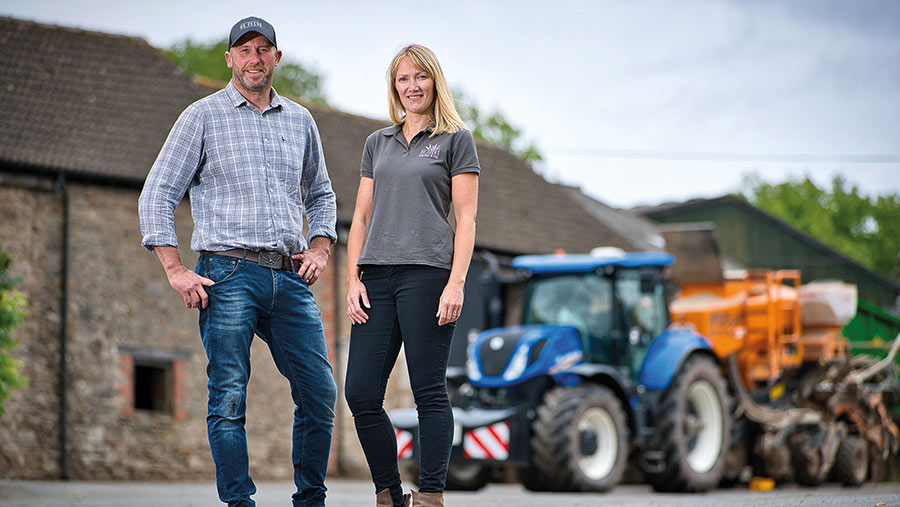 Julie and Tom Davies standing in farmyard with tractor