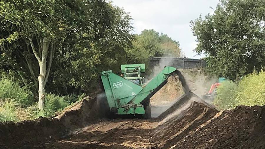 Composter at work on windrows of compost