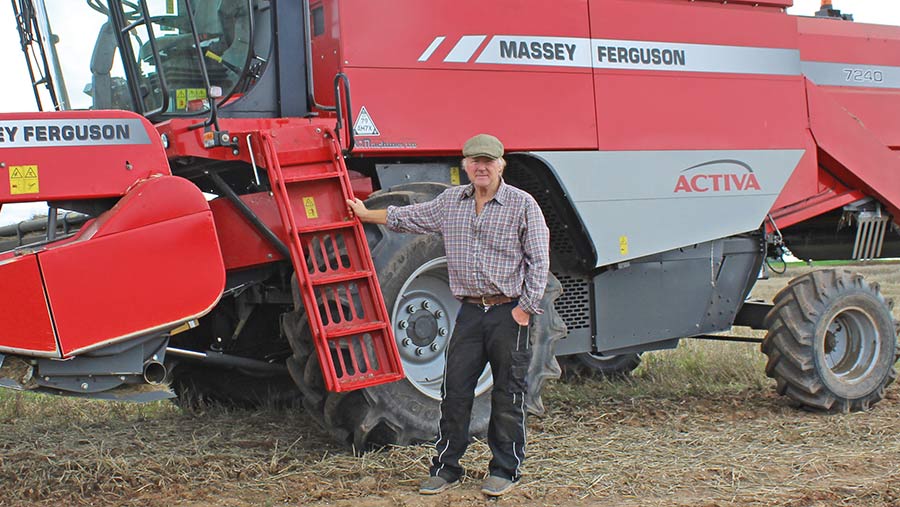 John Roberts stands beside his combine