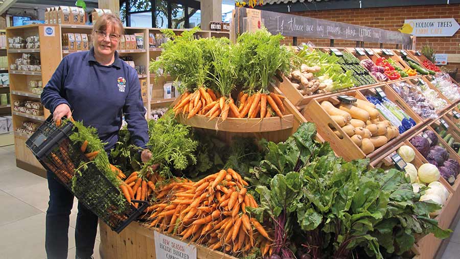 Sally Bendall with in farm shop with vegetables