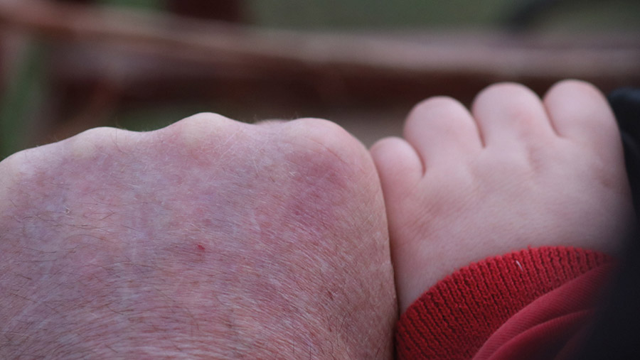 Man's hand next to child's hand