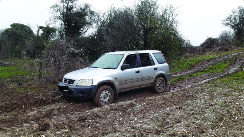 Grey Honda 4x4 stuck in mud after coursing incident