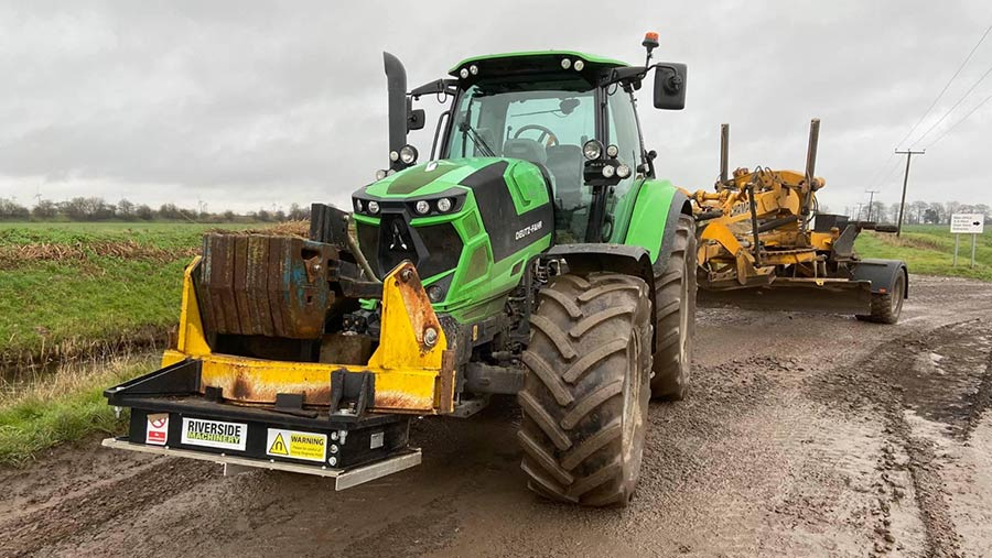 Tractor towing farm track grader