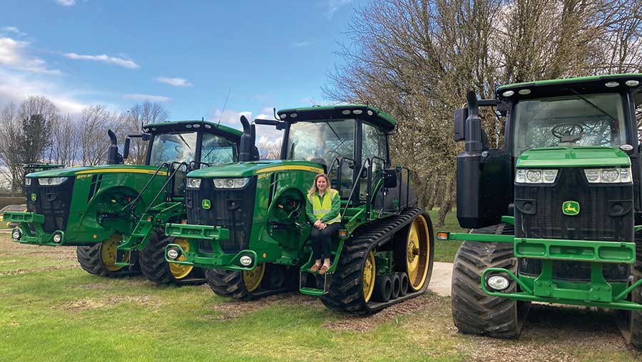 Masie Wildgoose next to John Deere tractor