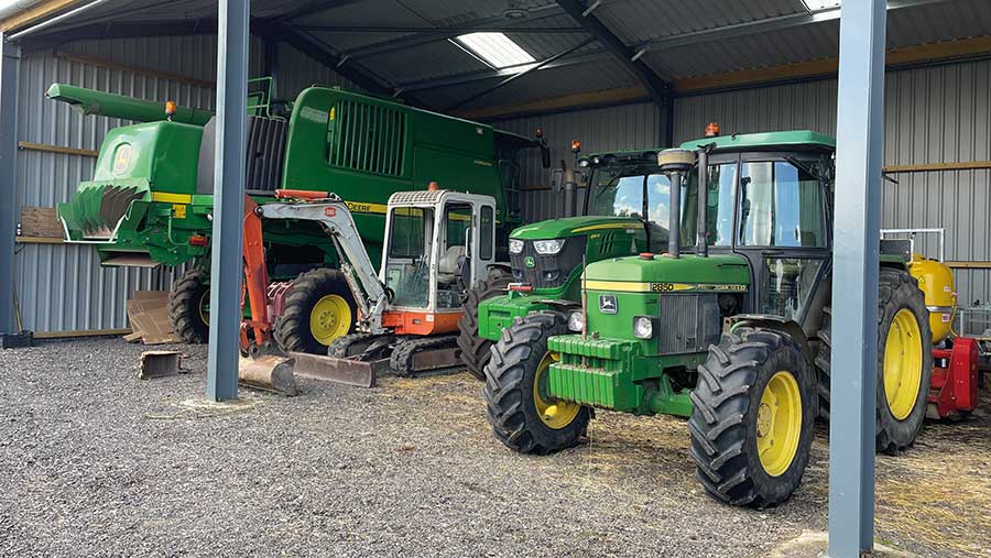 Combine, digger and tractors in farm shed