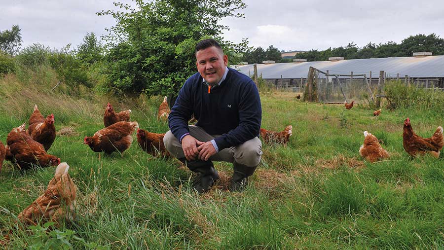 Mr Clarke with hens in a field