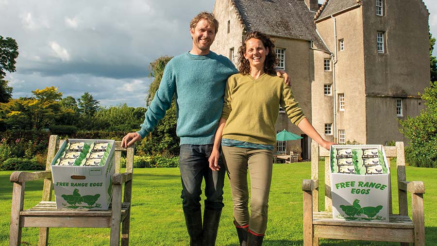 Couple stand with boxes of eggs