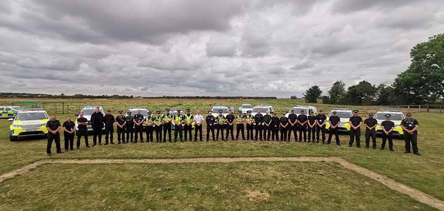 Long line of police officers with cars 