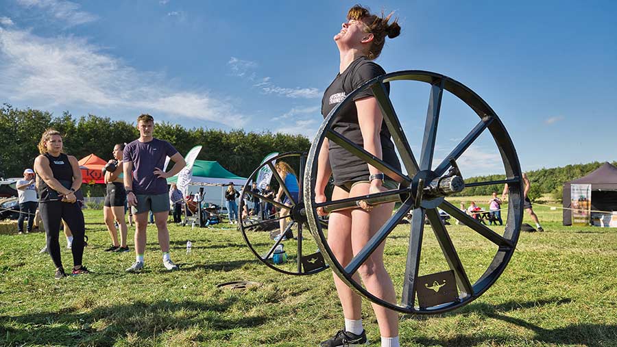 Britain's Fittest Farmer contestant lifting a wheel axle