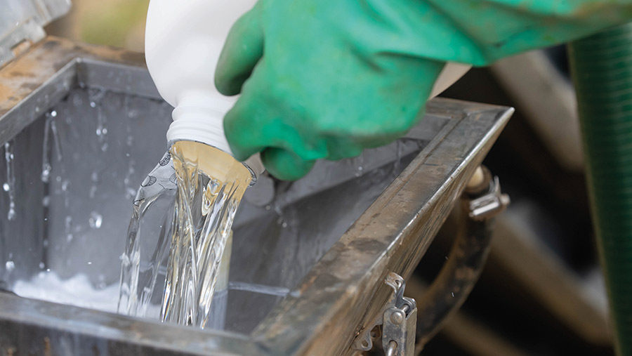 Pouring herbicide into sprayer