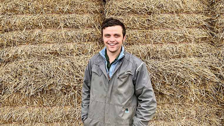Mike Neaverson in front of hay bales