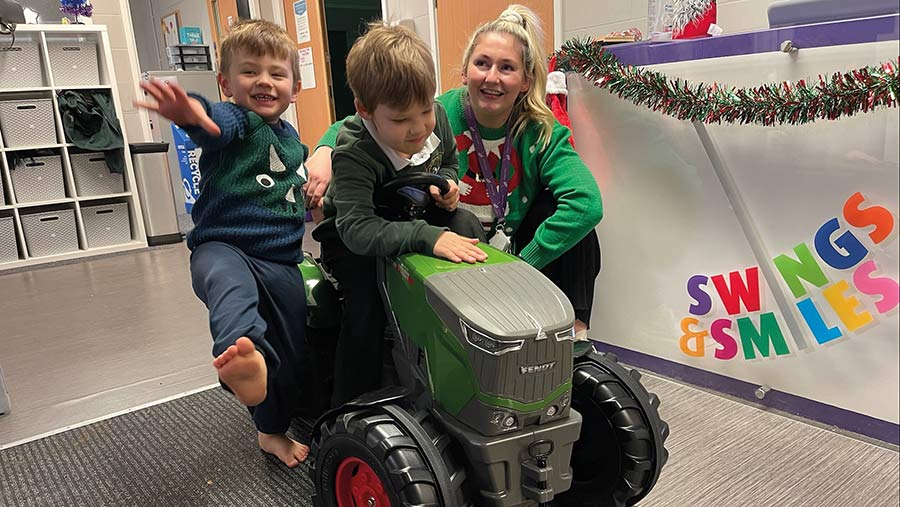 Children playing on toy tractor at Swings & Smiles