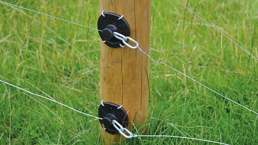 Plastic insulators on a fence post