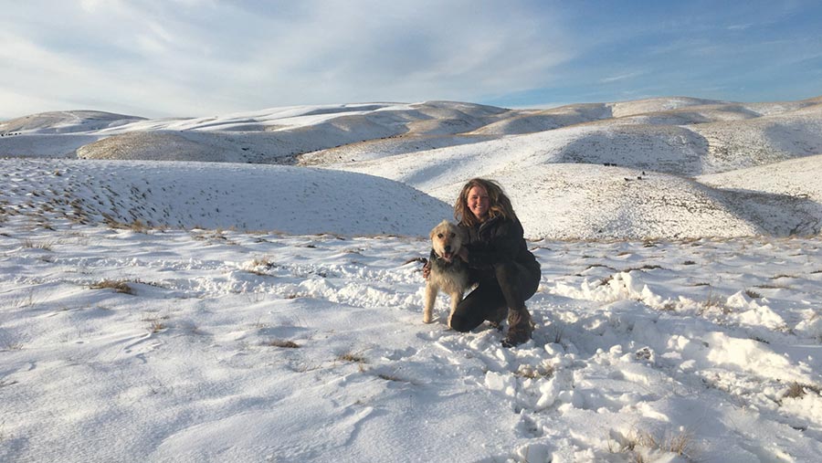 Emily in snow-covered field with her dog