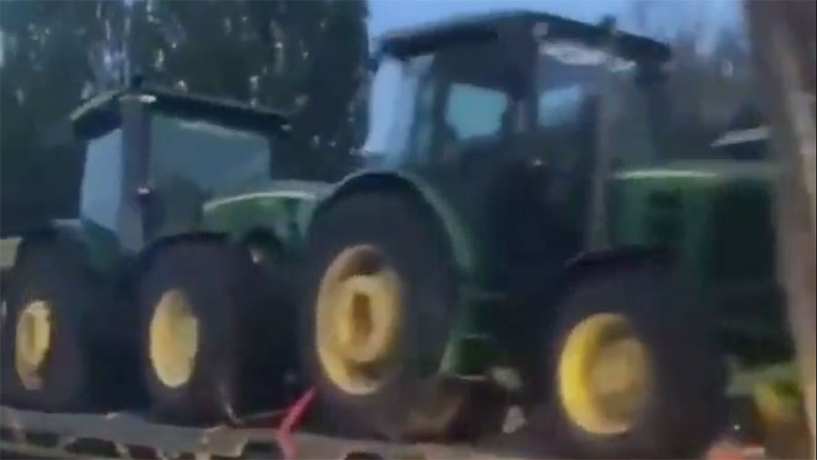 The video shows tractors and combines  on flatbed trailers © Twitter